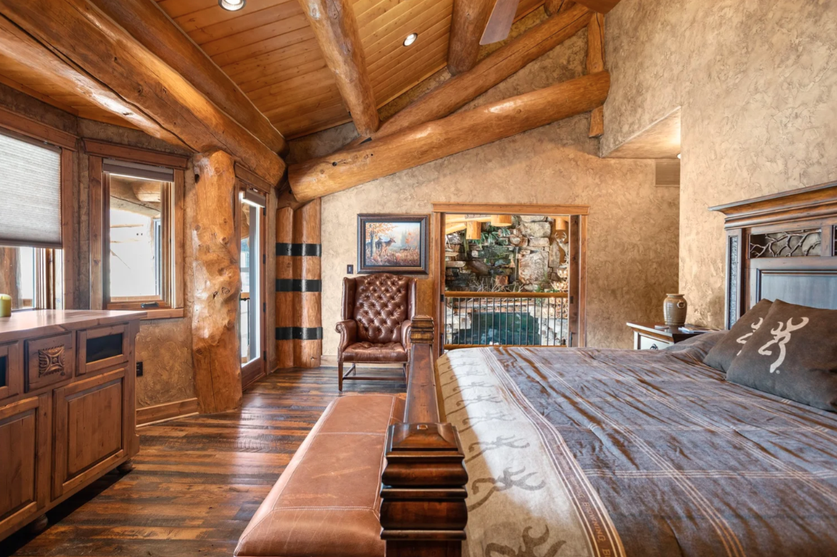 Warm plaster walls soften the heavy timber construction, while an open doorway offers a peek back out towards the great room.