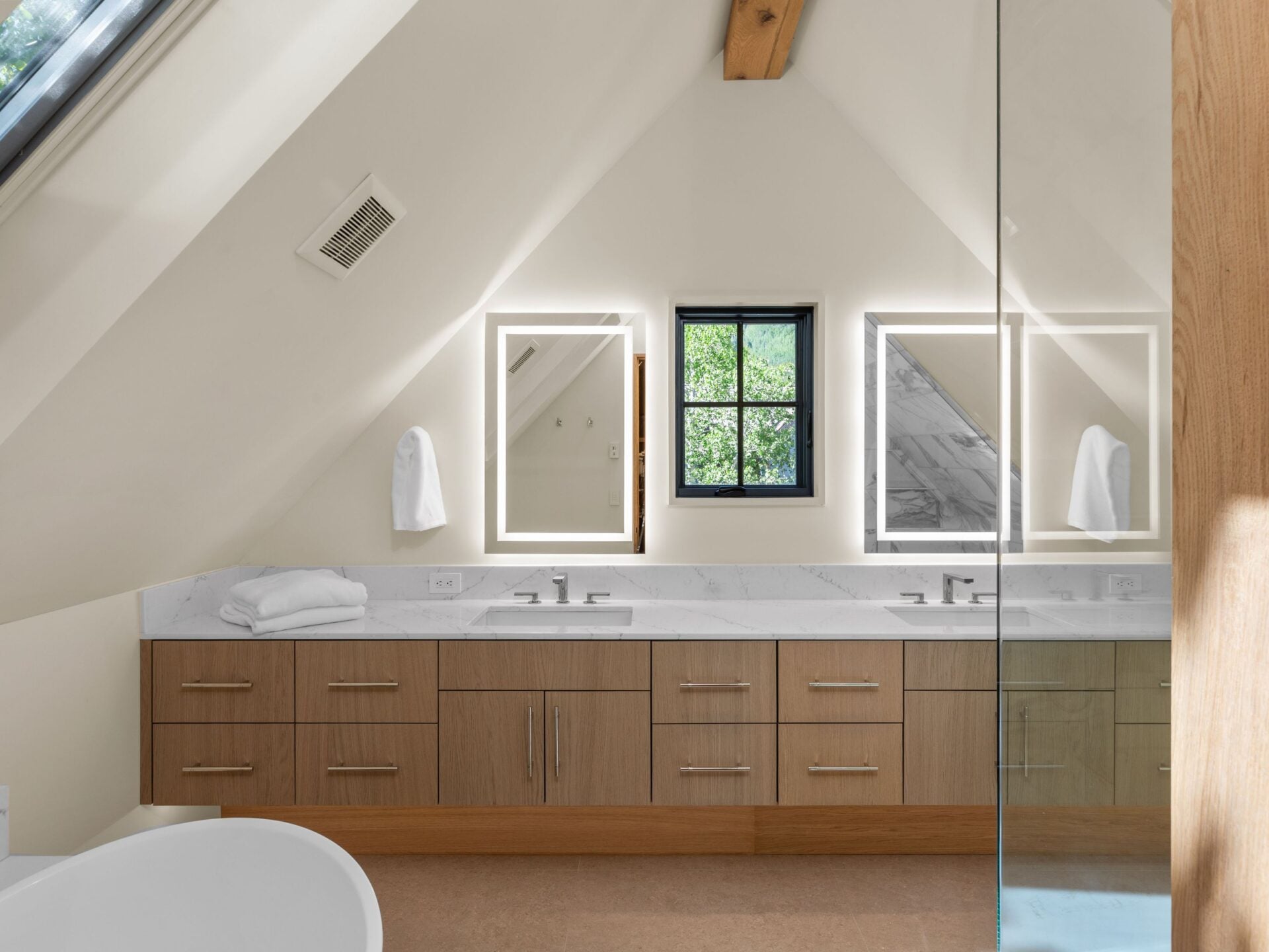Across from the marble-topped vanity sits a glass-enclosed shower and a freestanding tub to finish out the suite.