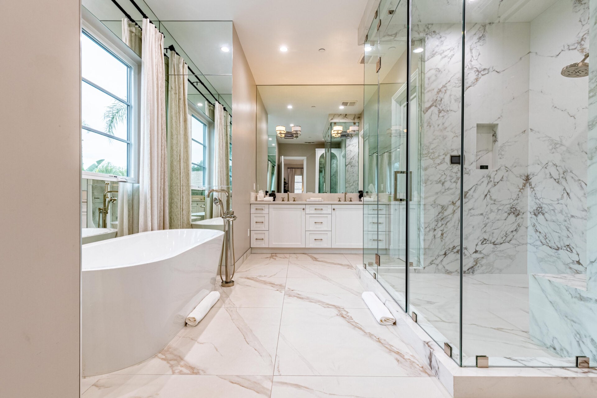 The suite's bathroom has a freestanding soaking tub that sits across from an oversized glass-enclosed steam shower.