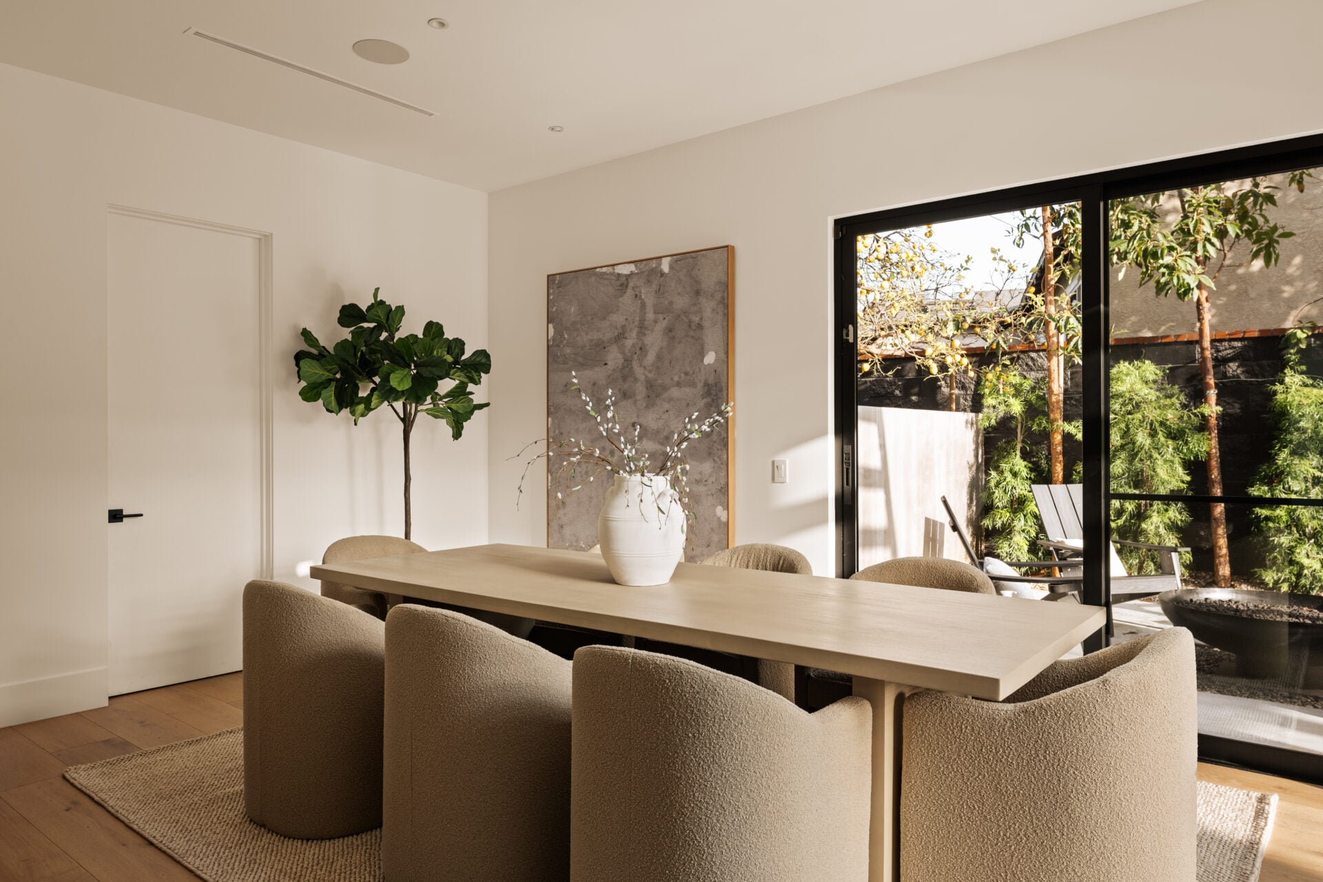 The dining room sits just off the great room with a long rectangular table surrounded by soft upholstered chairs.