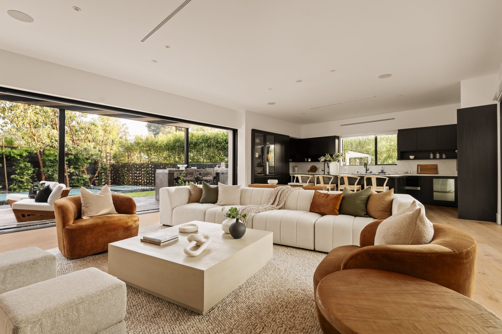 A large couch and rounded velvet chairs create the main sitting area, between sliding glass walls thst open along both sides of the room.