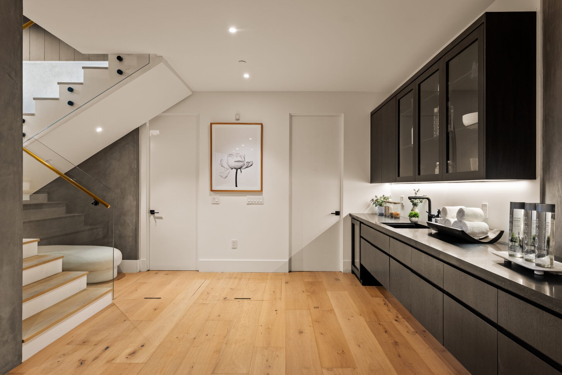 The lower level opens at the base of the staircase with a built-in wine and wet bar running along one wall.