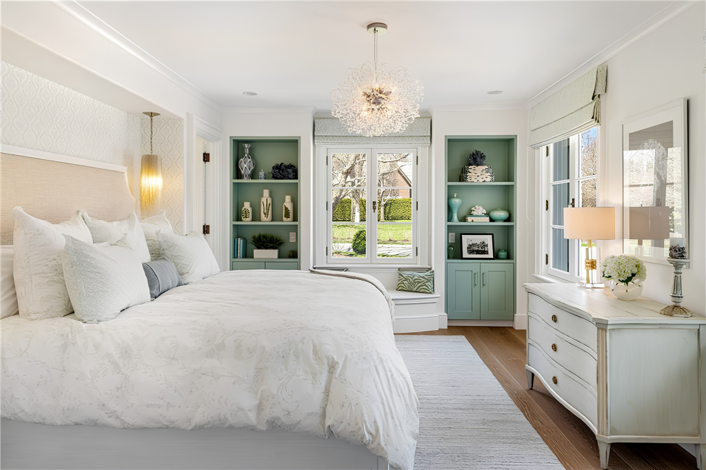 This bedroom has the bed set along one wall and a pair of built-in bookcases framing a window seat at the far end.