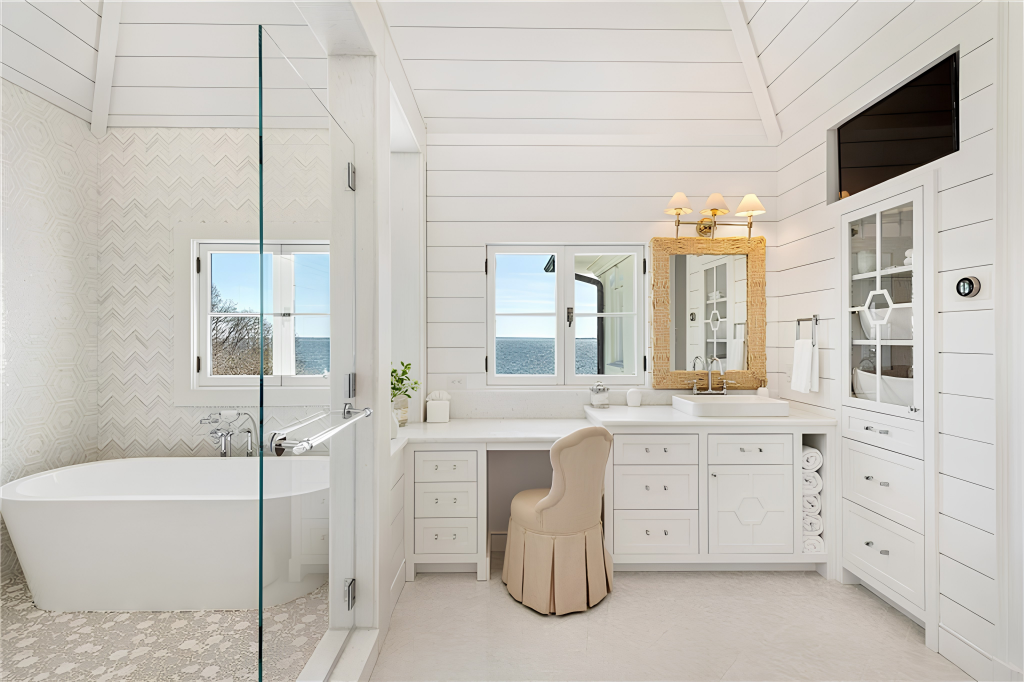 Bathroom includes a freestanding soaking tub that sits against a chevron-patterned wall within the glass-enclosed shower.