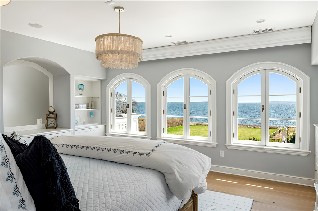 Upstairs, another suite is positioned to face the water, with the bed facing three arched windows opening the room to ocean views.