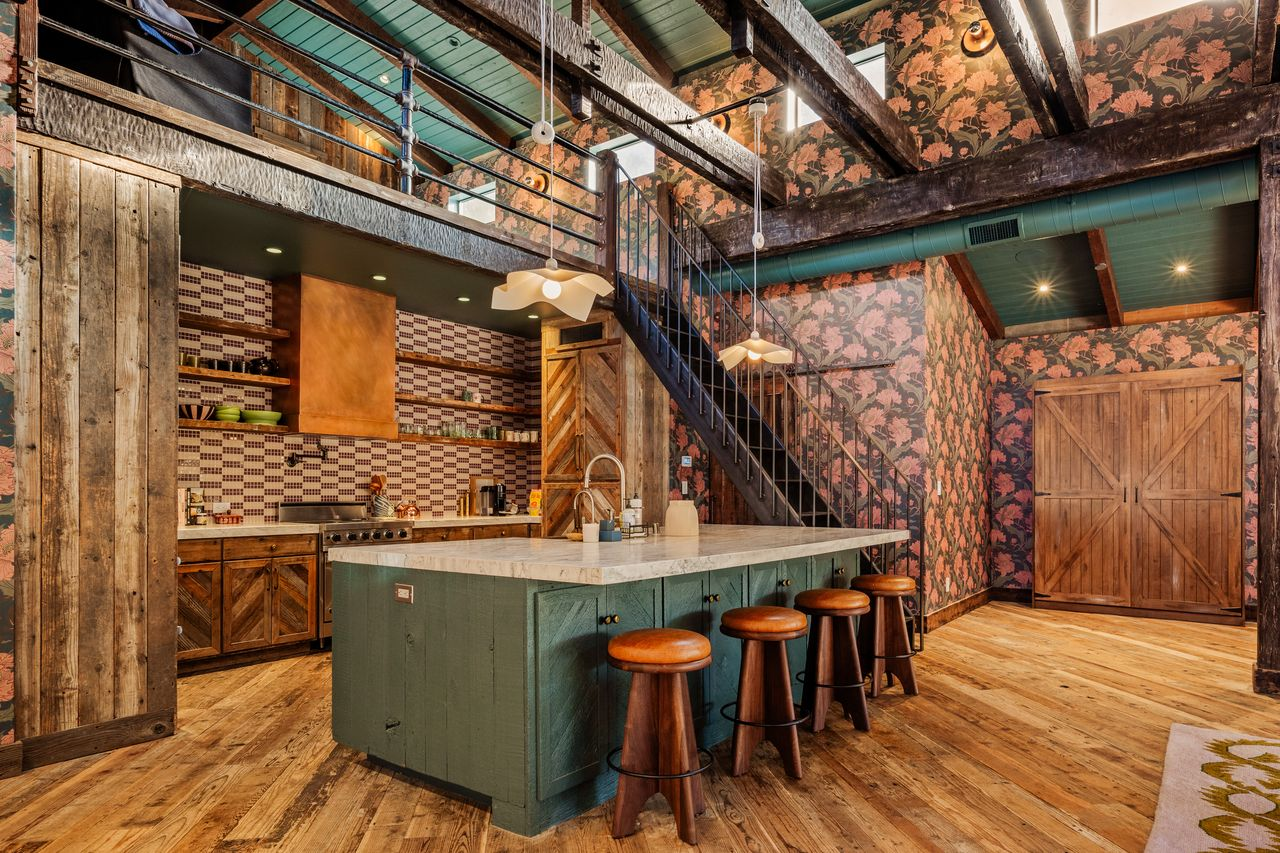 On the other side, a kitchen is built directly into the open entertaining area with barstools lining the edge of a large island. 