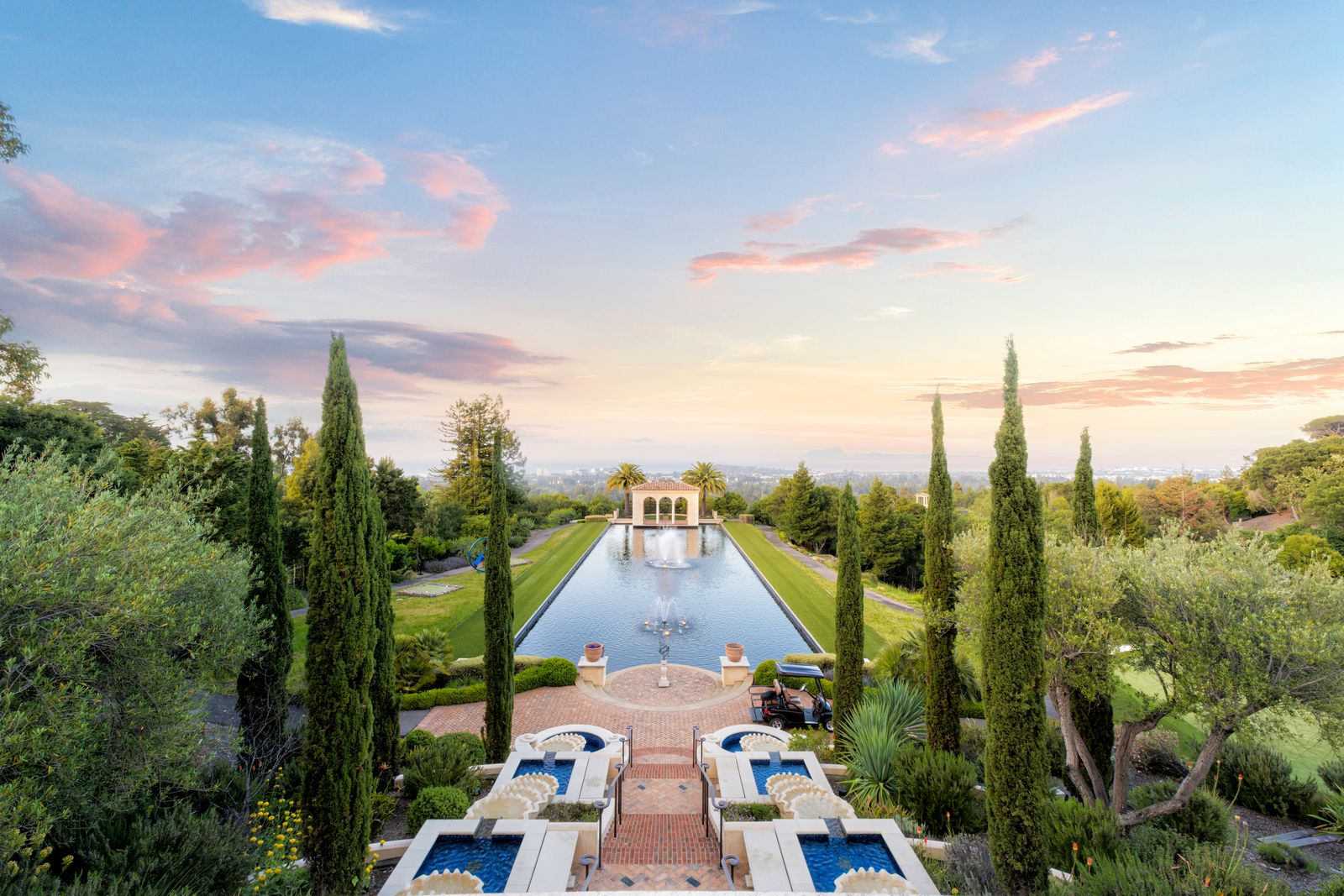 A series of cascading fountains descends through the landscaping toward a massive reflection pond.