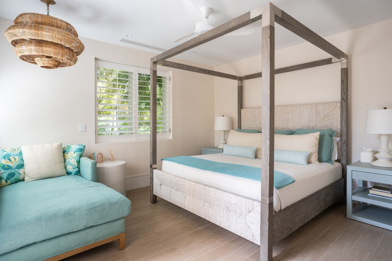 The second suite has a tall four-poster canopy bed, with a chaise positioned along one side. 
