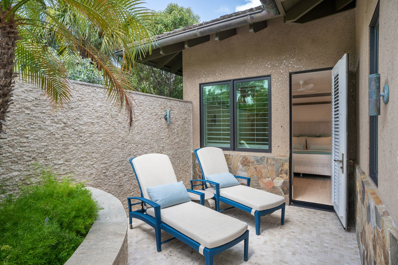 Private terrace enclosed in stone walls with two lounge chairs placed within the small space.