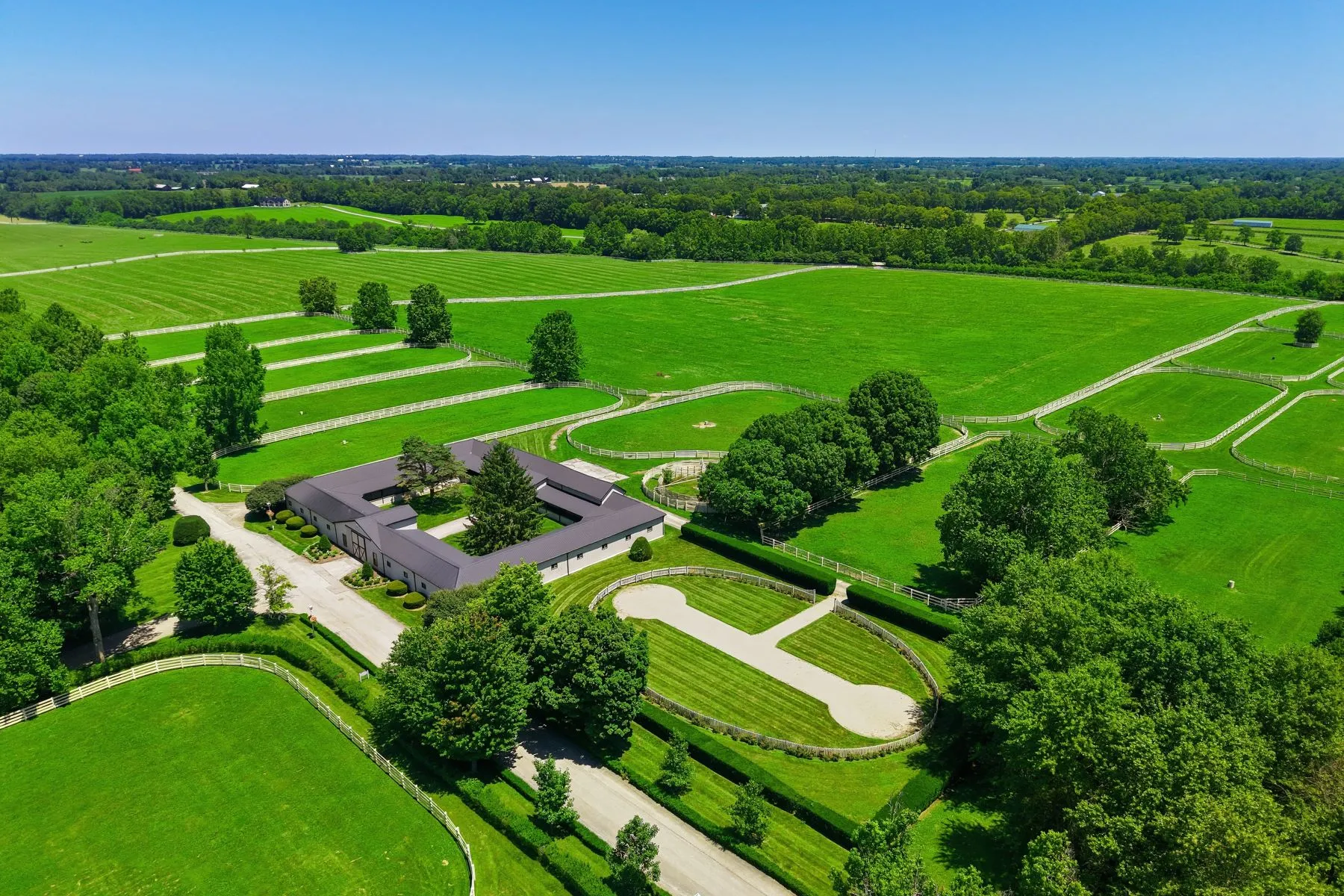 Large stable complex surrounded by open pastures.
