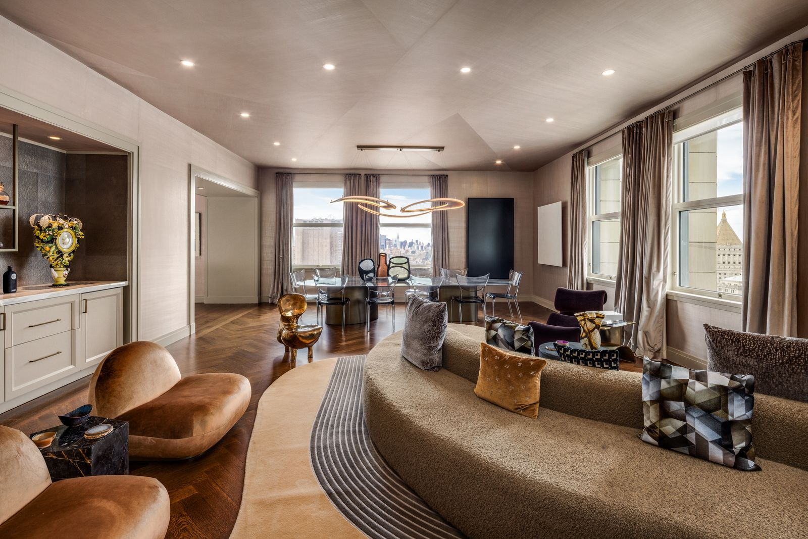 The corner great room stretches more than 35 feet beneath ceilings rising over 10 feet, with solid oak herringbone floors running continuously through the space.