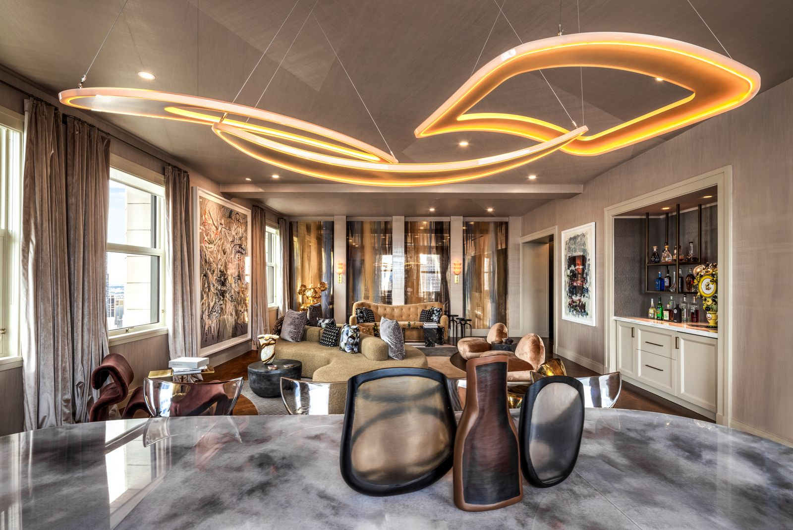 Between the dining area and living space, a built-in wet bar is finished with hand-painted églomisé mirror panels.