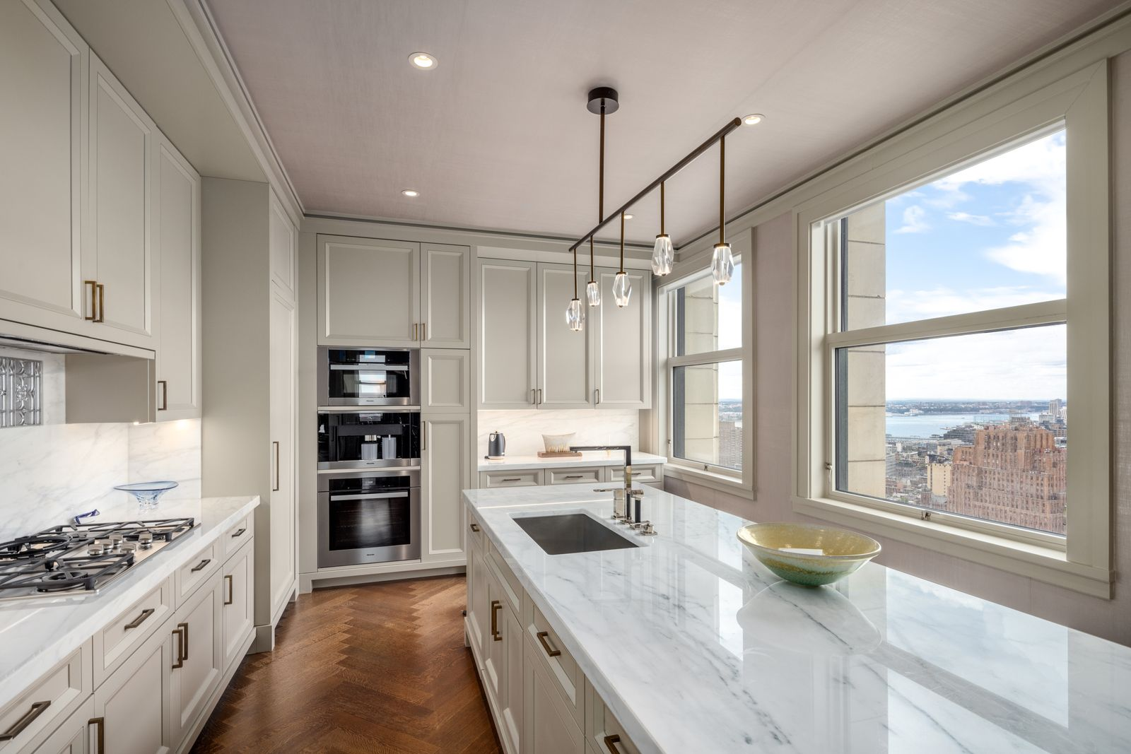 Along the windowed side, the island incorporates the sink and Dornbracht fixtures which face the city views while the stovetop sits across the room.
