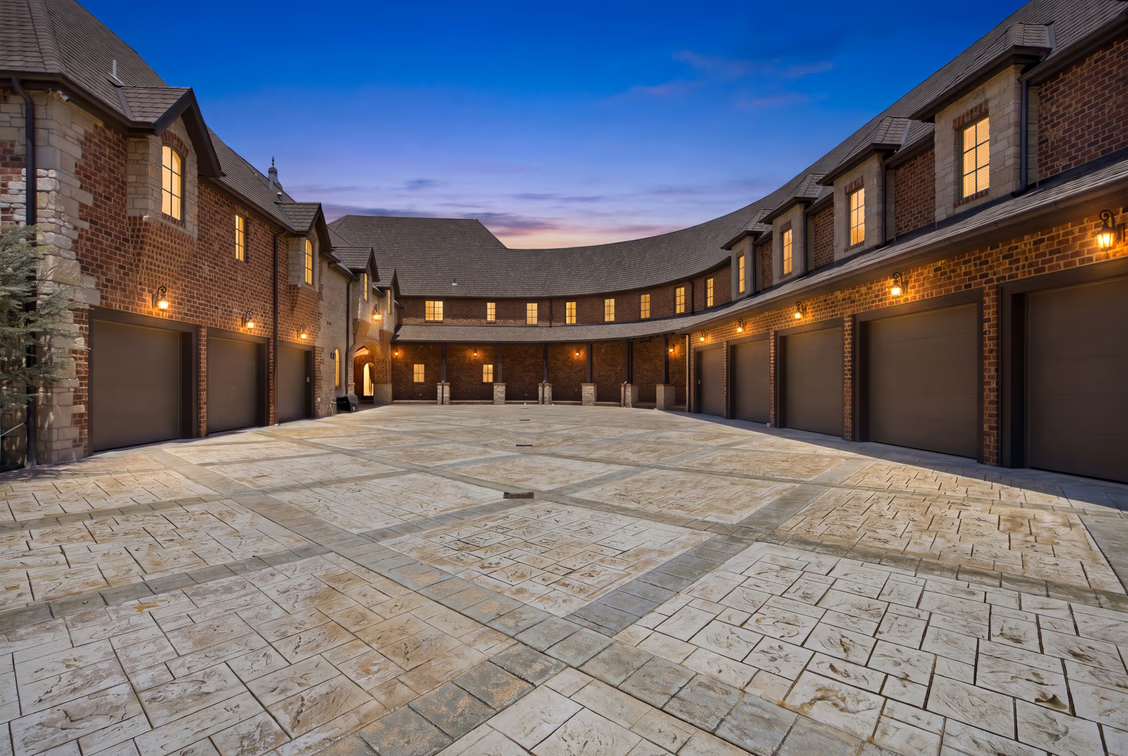 The home has a brick-and-stone exterior framing the long row of garage bays.