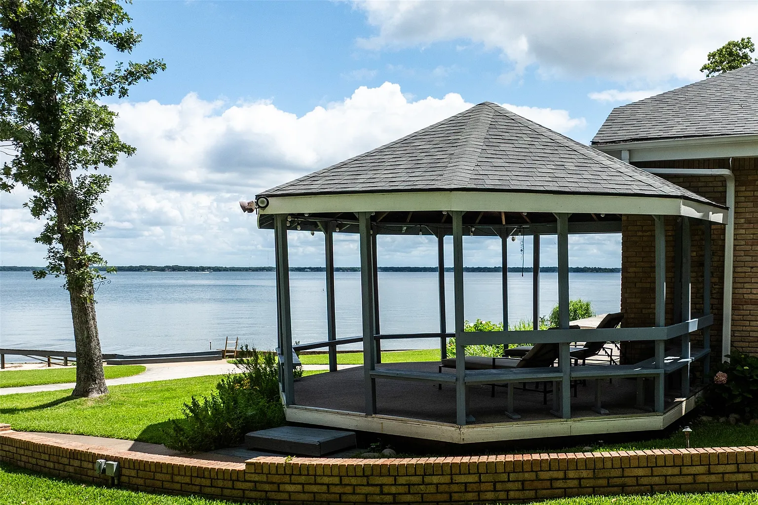 A gazebo sits at the edge of the house with open views across Cedar Creek Lake. 