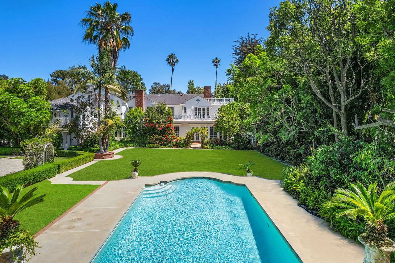 Past the lawn, the swimming pool is surrounded by stone terraces.