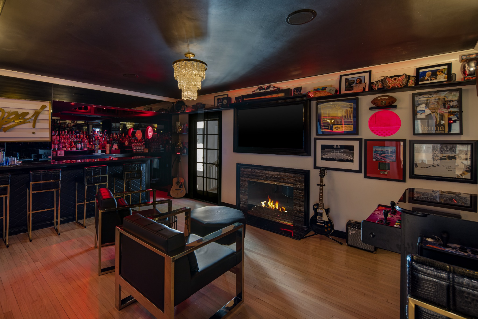 Bar room has a darker look than the rest of the interiors, with a black ceiling, red accent lighting, and a full bar lined with stools. 