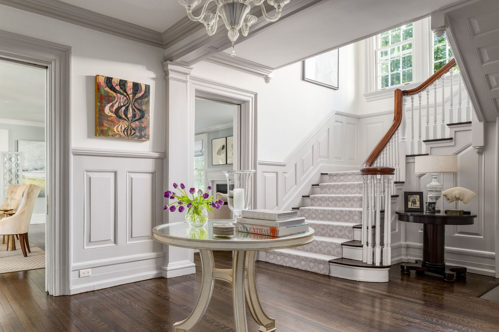 Beyond the double-door entrance, the home opens to a central foyer atop dark hardwood floors with a staircase at the back. 