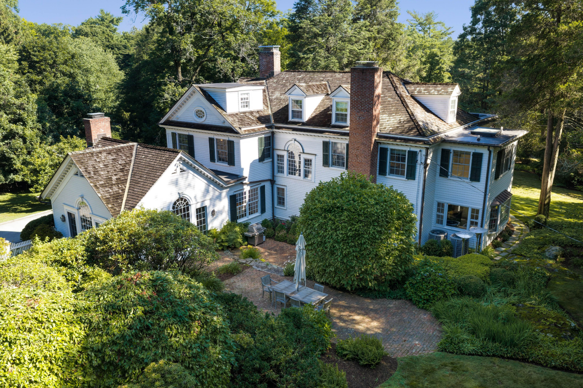 Back of the house extends onto a brick patio.