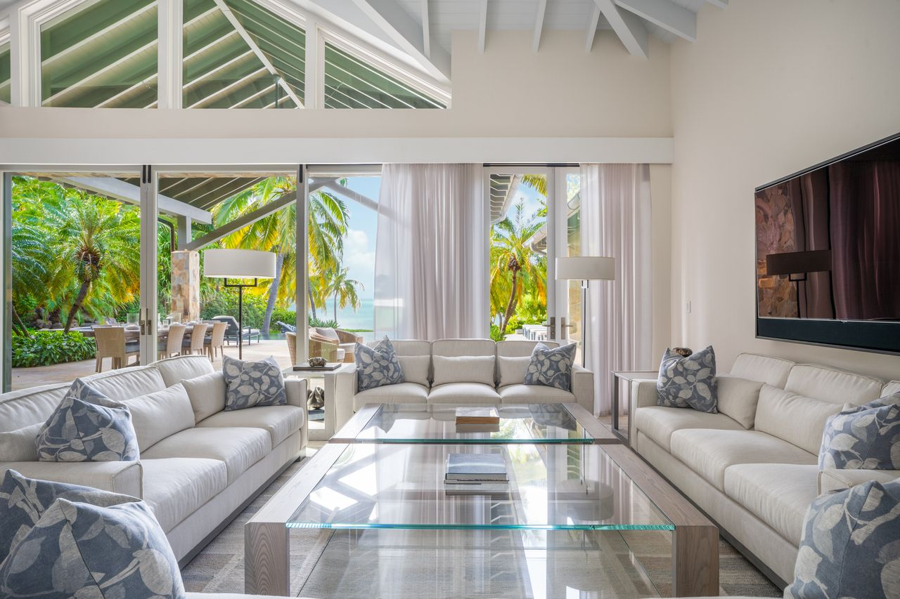 The living area is is set up as a square with four sofas surrounding a pair of glass-topped coffee tables.