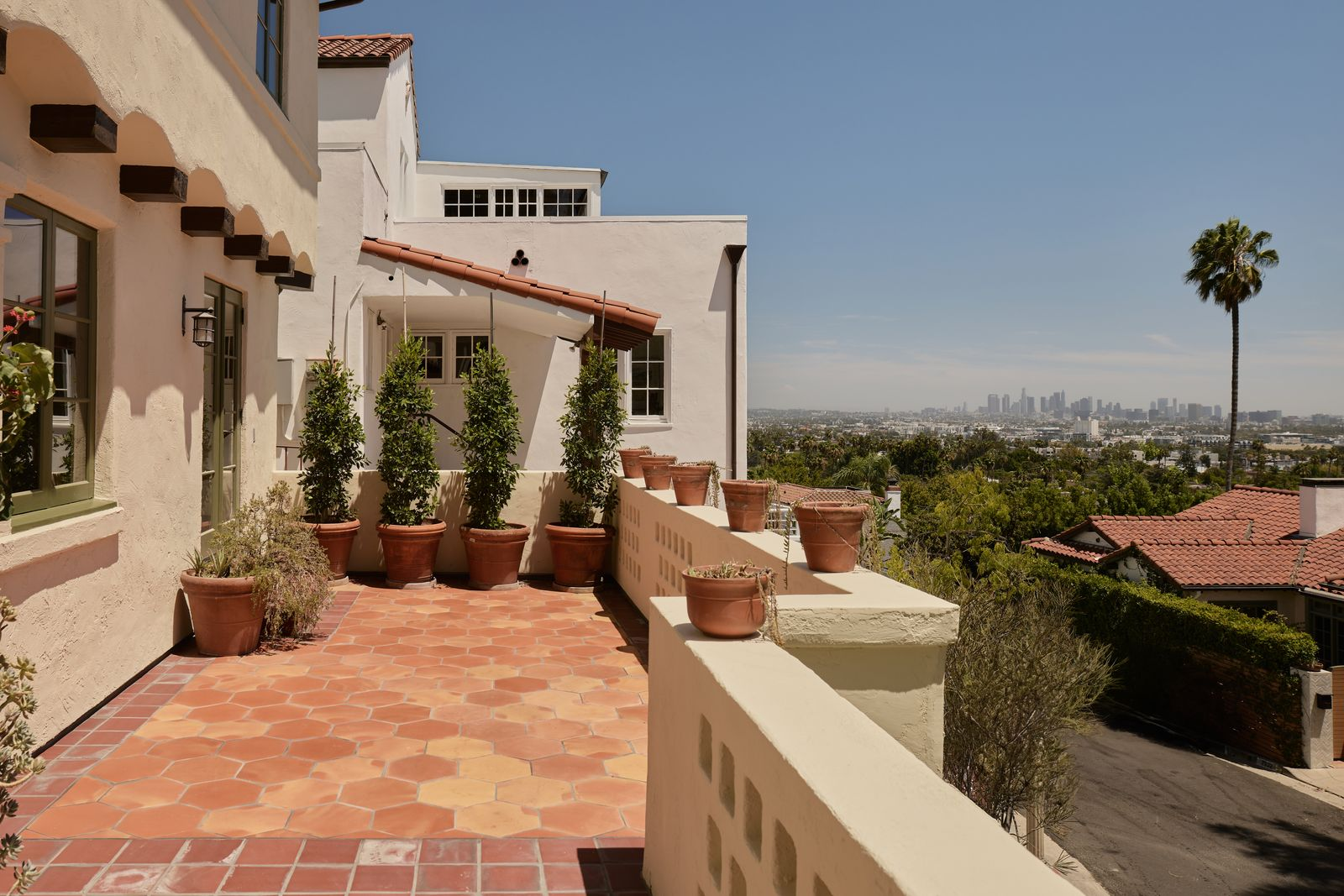 LA city views from a terracotta tile balcony.