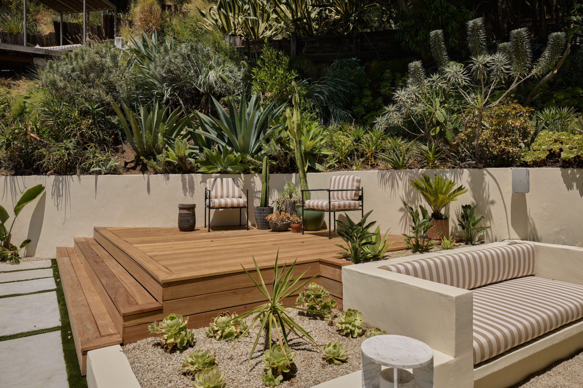 A pair of chairs sits on the upper portion of the deck, while a built-in bench creates another place to sit at the lower edge.