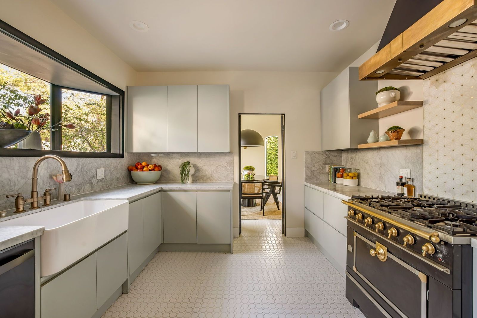 A compact kitchen lined with streamlined gray cabinetry and marble countertops.
