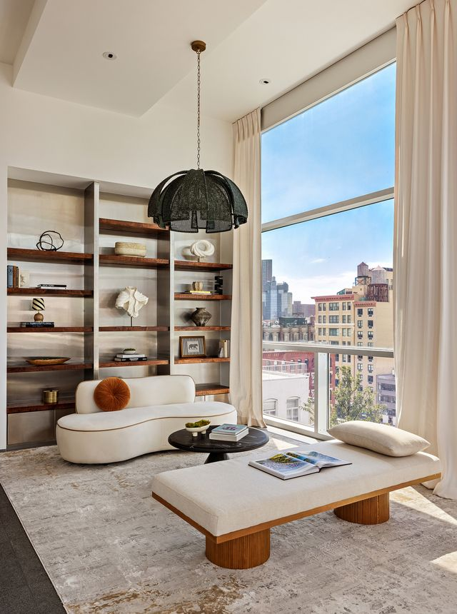 Built-in shelving lines one side next to a full wall window.