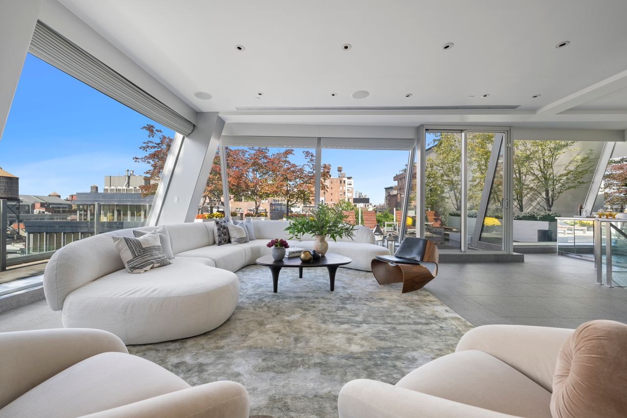 The penthouse opens into a separate media room wrapped in angled glass walls.