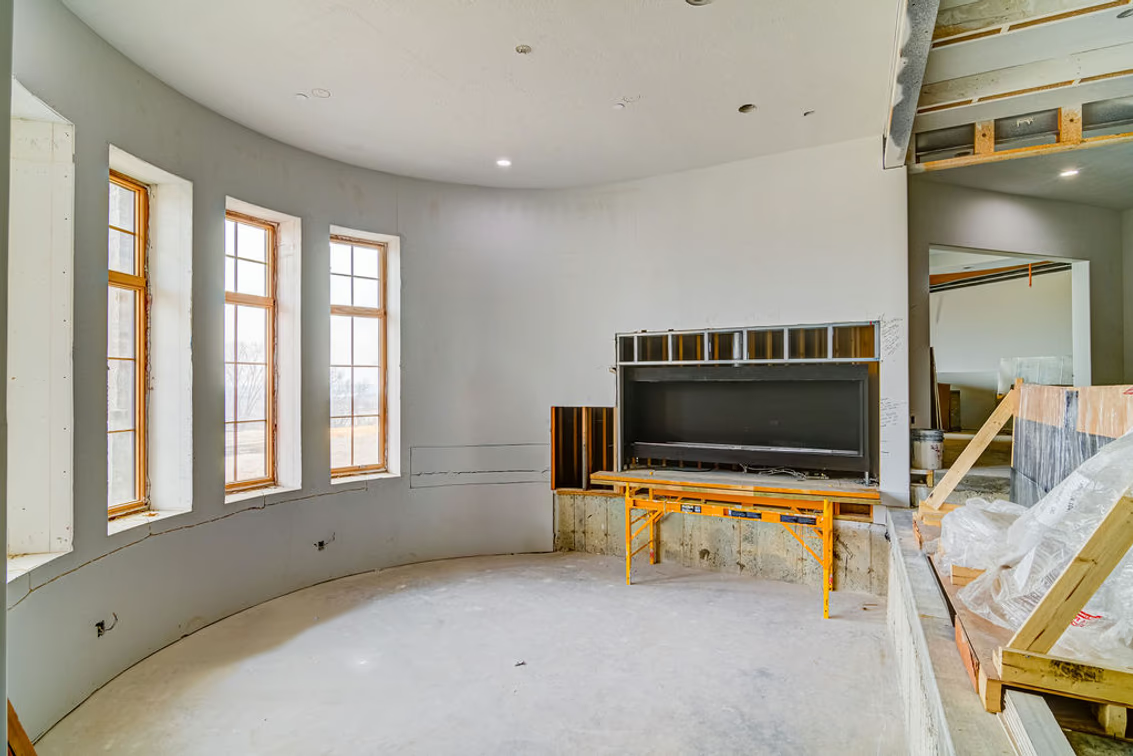 The sunken lounge facing a curved wall of windows.