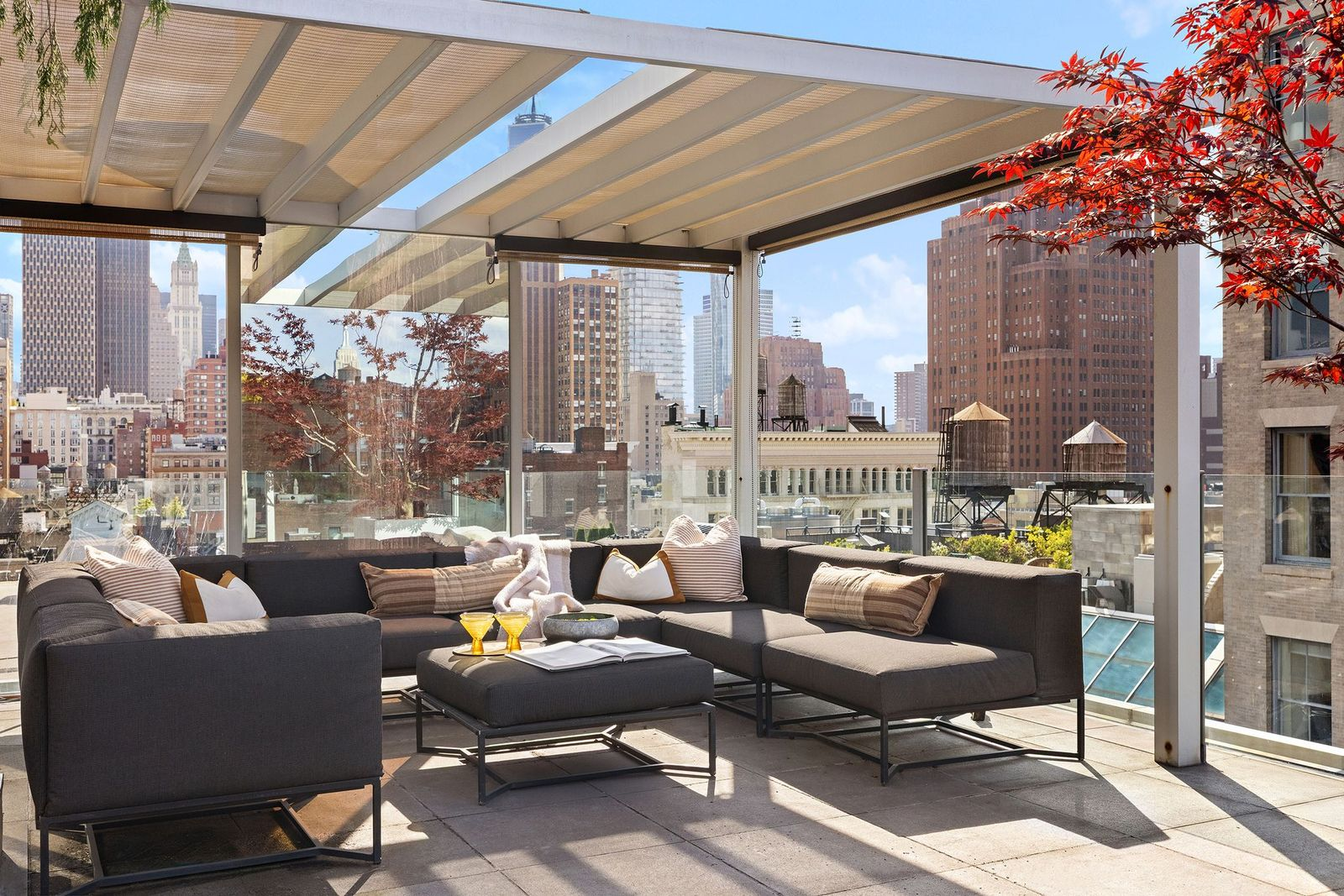 A covered lounge beneath a pergola, creating a shaded place to sit while still keeping the surrounding skyline fully in view.