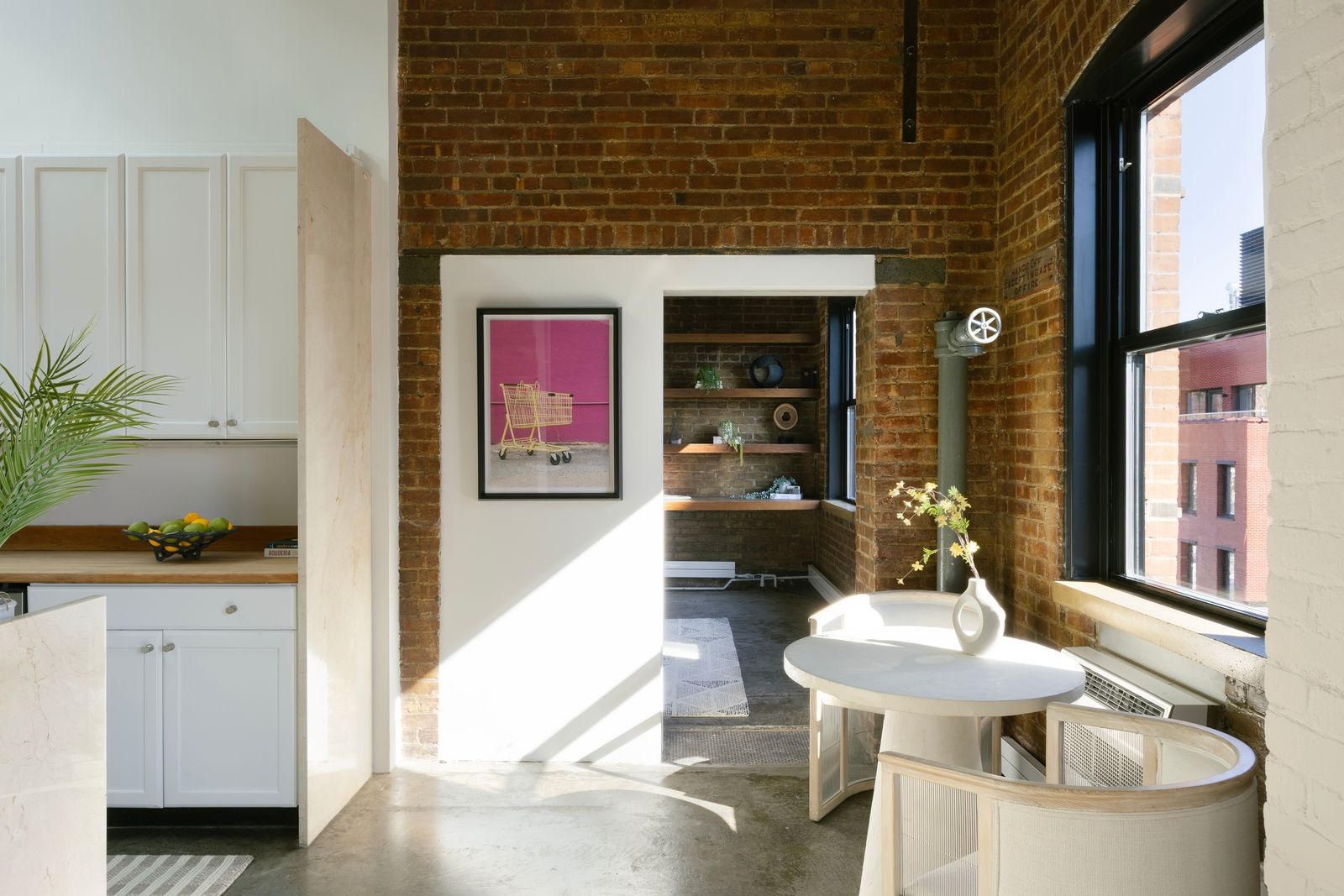 A small breakfast area at the far end of the kitchen beneath a window.