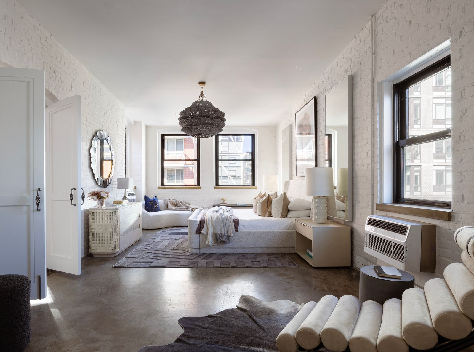 The corner primary bedroom once again sees white-painted brick wrapping around windows with views toward the High Line.