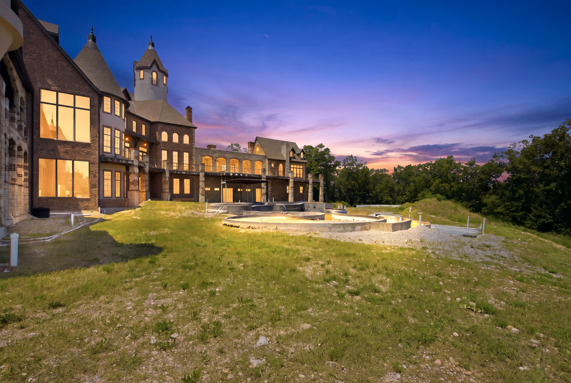 Farther into the backyard is a pool with a beach-style entrance and an infinity edge extending toward Table Rock Lake.