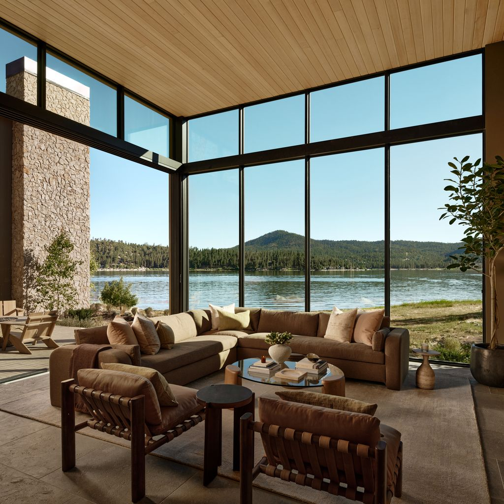 Living room designed in a warm palette of walnut, camel, and terracotta, with wood accents lining the chairs, tables, and ceiling.