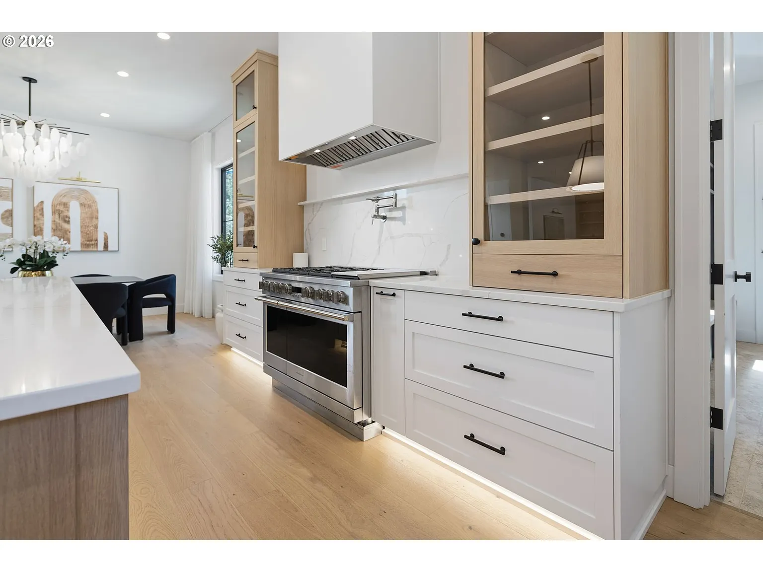 The other side of the center island is a stainless steel oven sitting beneath a marble-look backsplash.