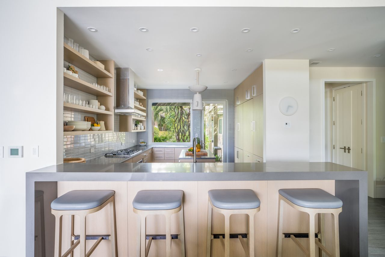 The gourmet family kitchen begins with a breakfast bar with four counter stools.