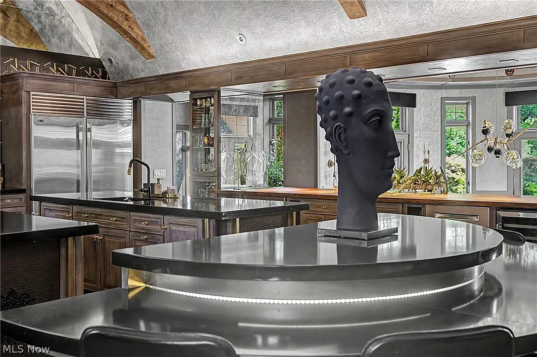 Kitchen centered around two large stainless-steel islands and a curved breakfast nook.