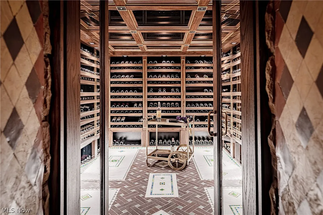 The wine cellar is built around floor-to-ceiling bottle storage that wraps nearly every wall. 