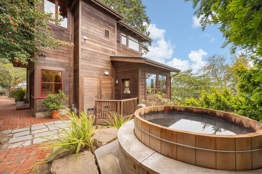 A Japanese soaking tub sits on a raised platform beside the house.