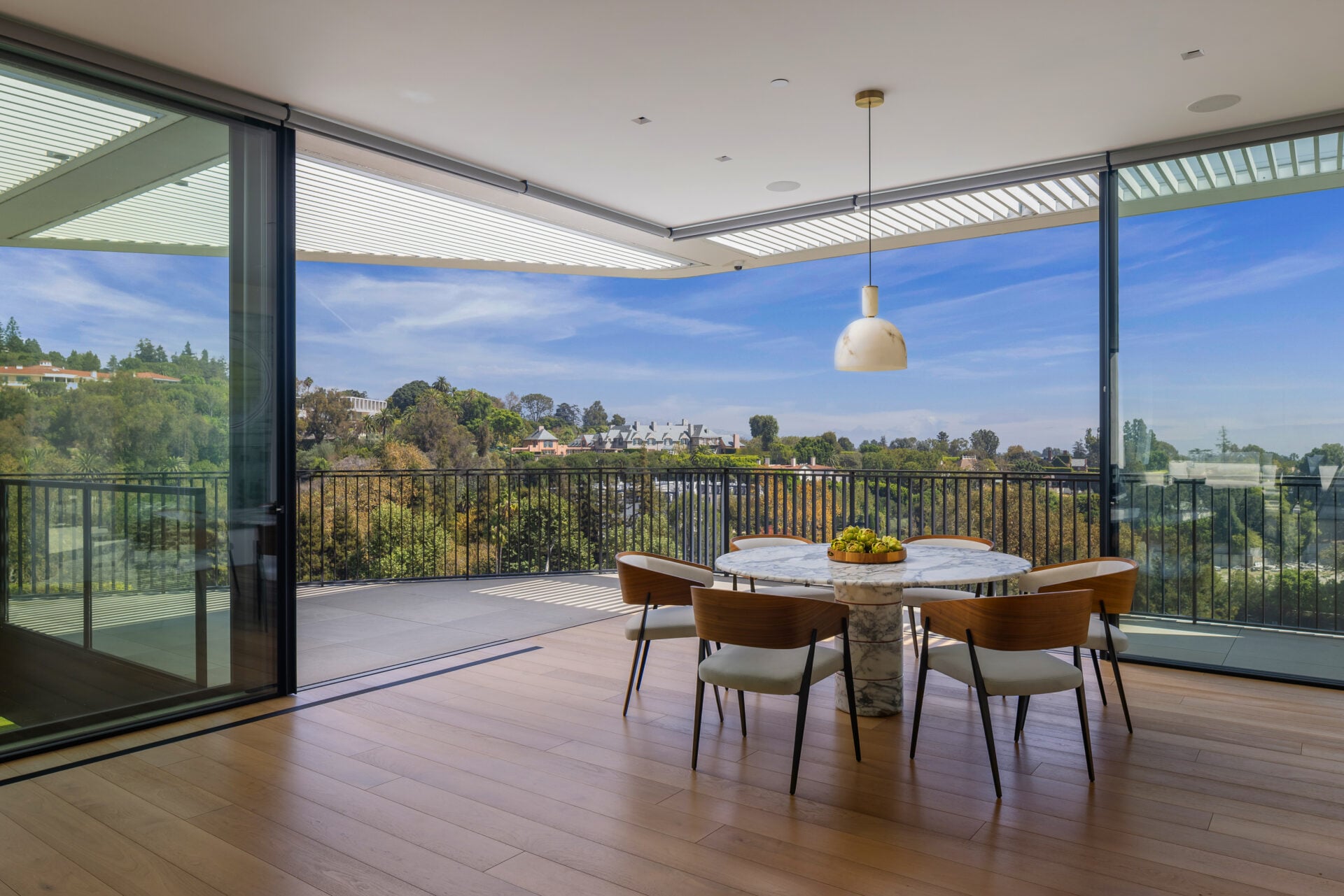 A breakfast nook sits against a corner of retractable glass, allowing the walls to open almost completely to the terrace.