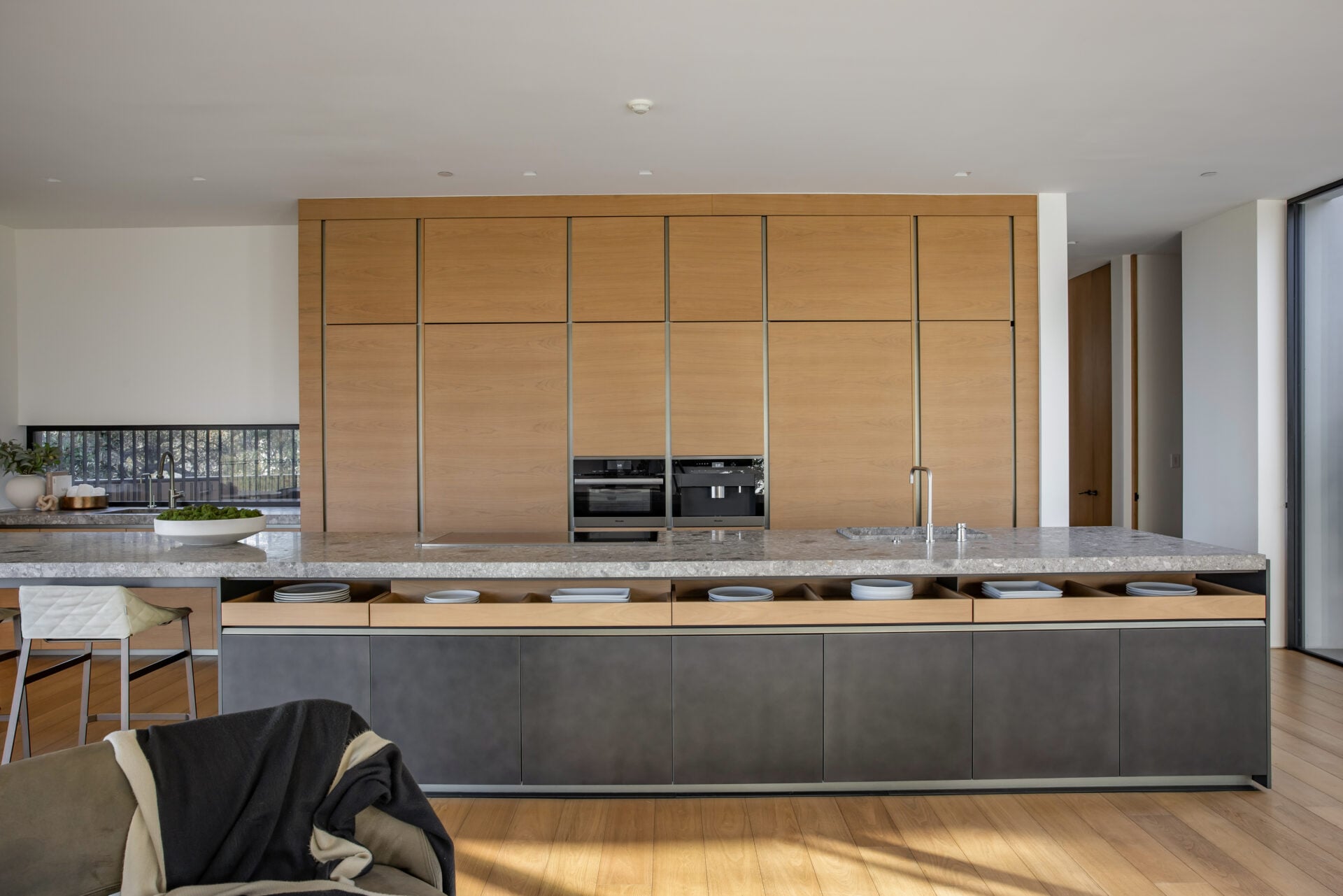 A breakfast nook sits against a corner of retractable glass, allowing the walls to open almost completely to the terrace.