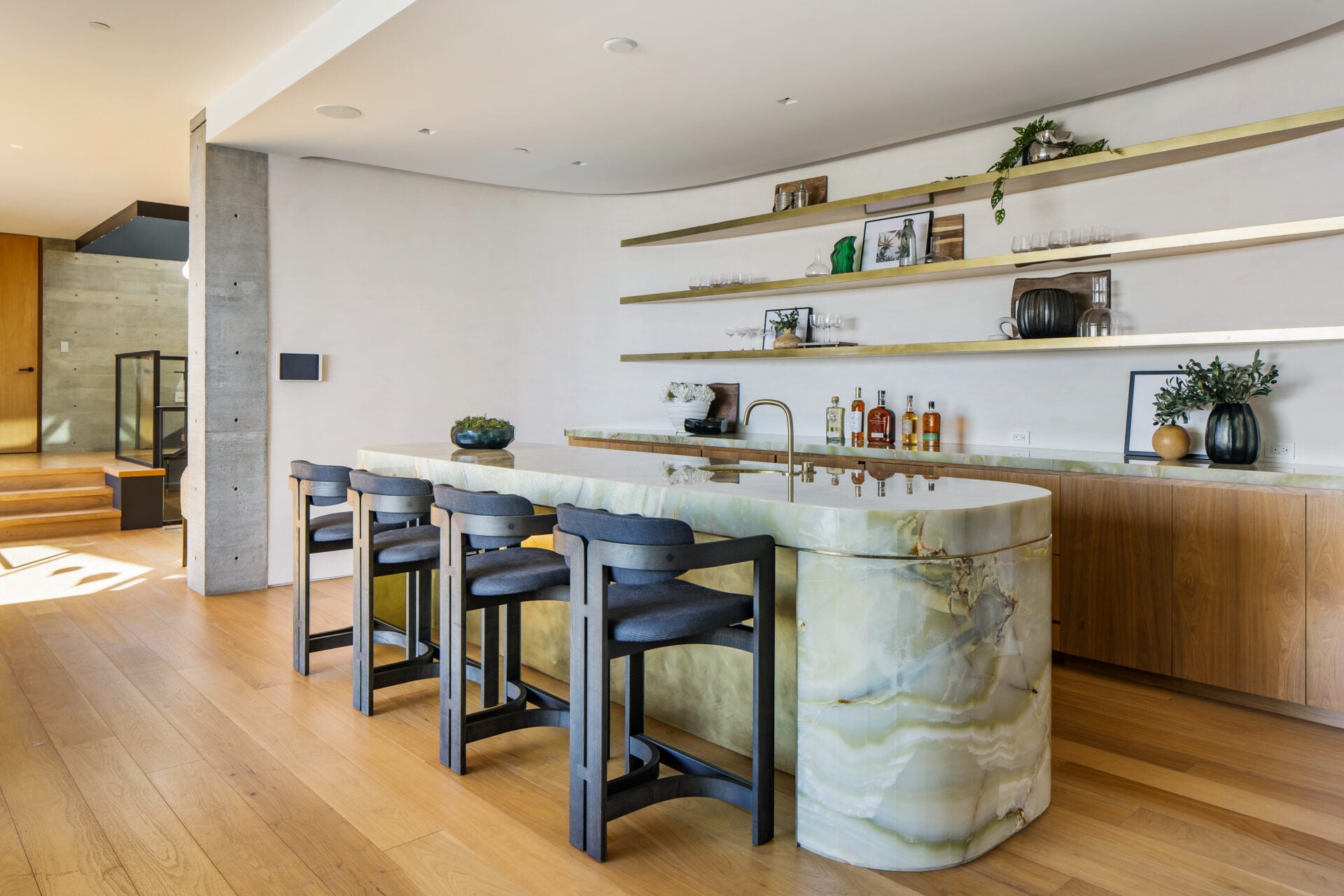 Long stone topped bar lined with barstools.