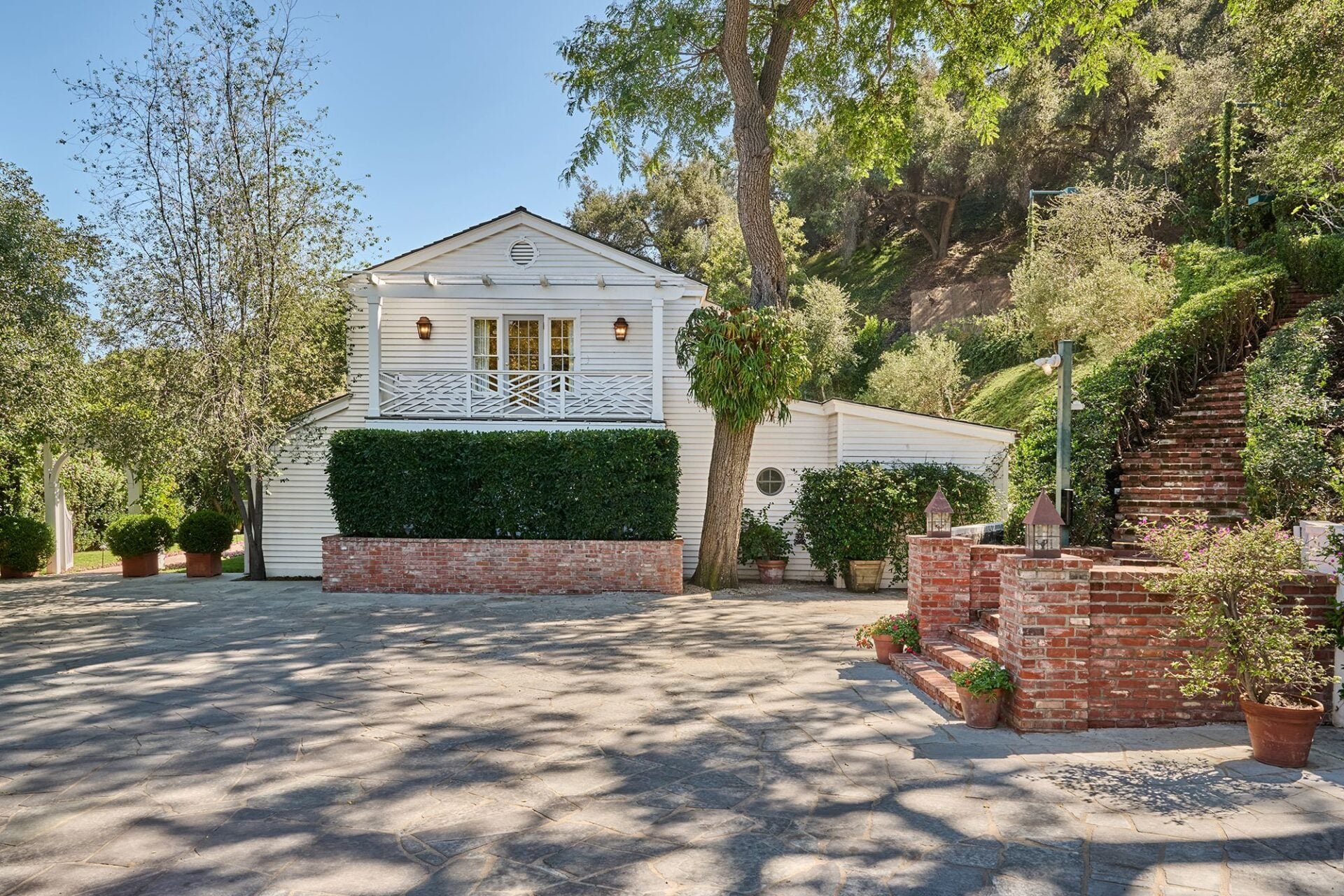 Surrounded by about a dozen live oak trees, the three bed and three-and-a-half bathroom house sits next to a terraced hillside.