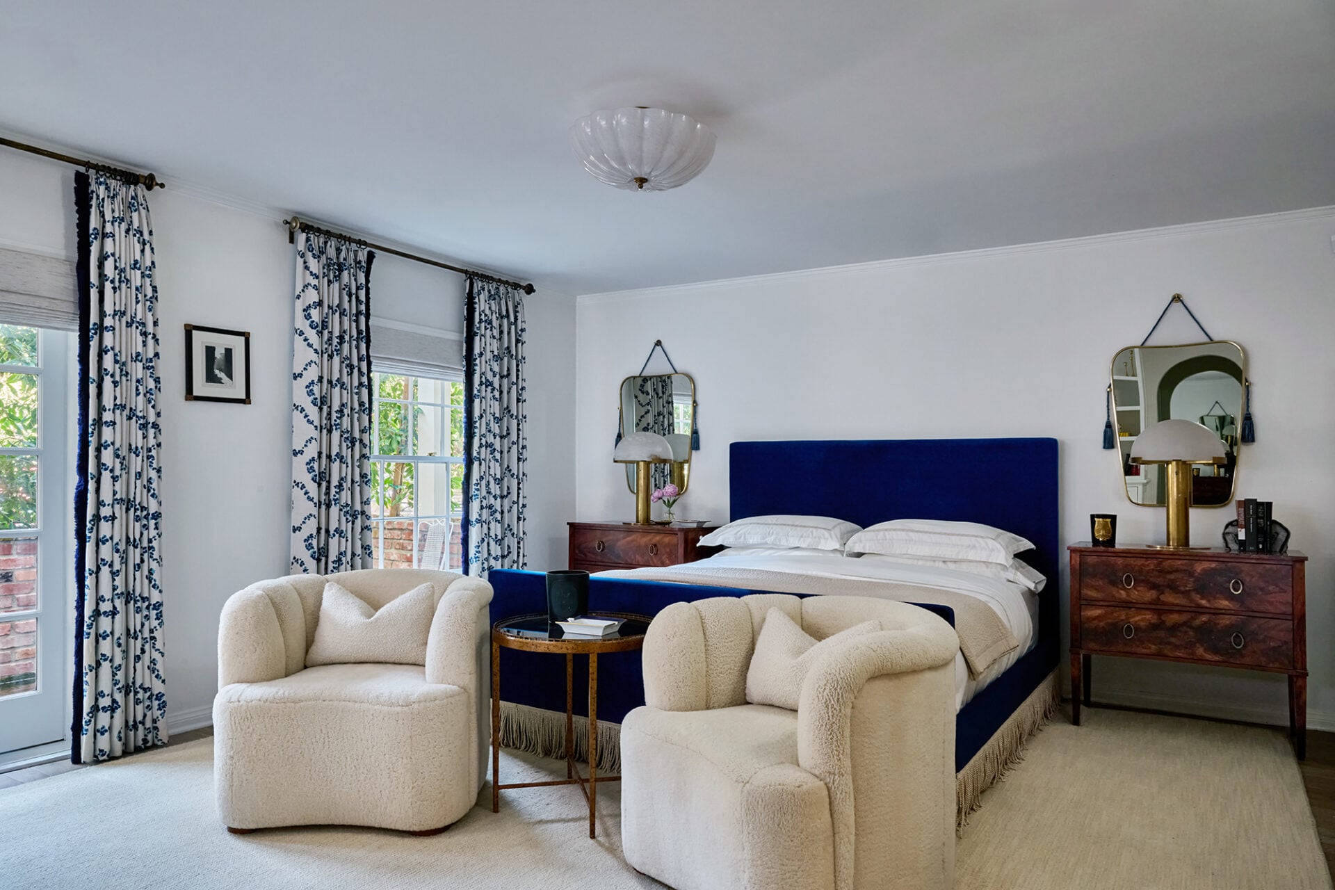 The primary suite is located on the main floor, with the bedroom featuring multiple French doors opening to the grounds.
