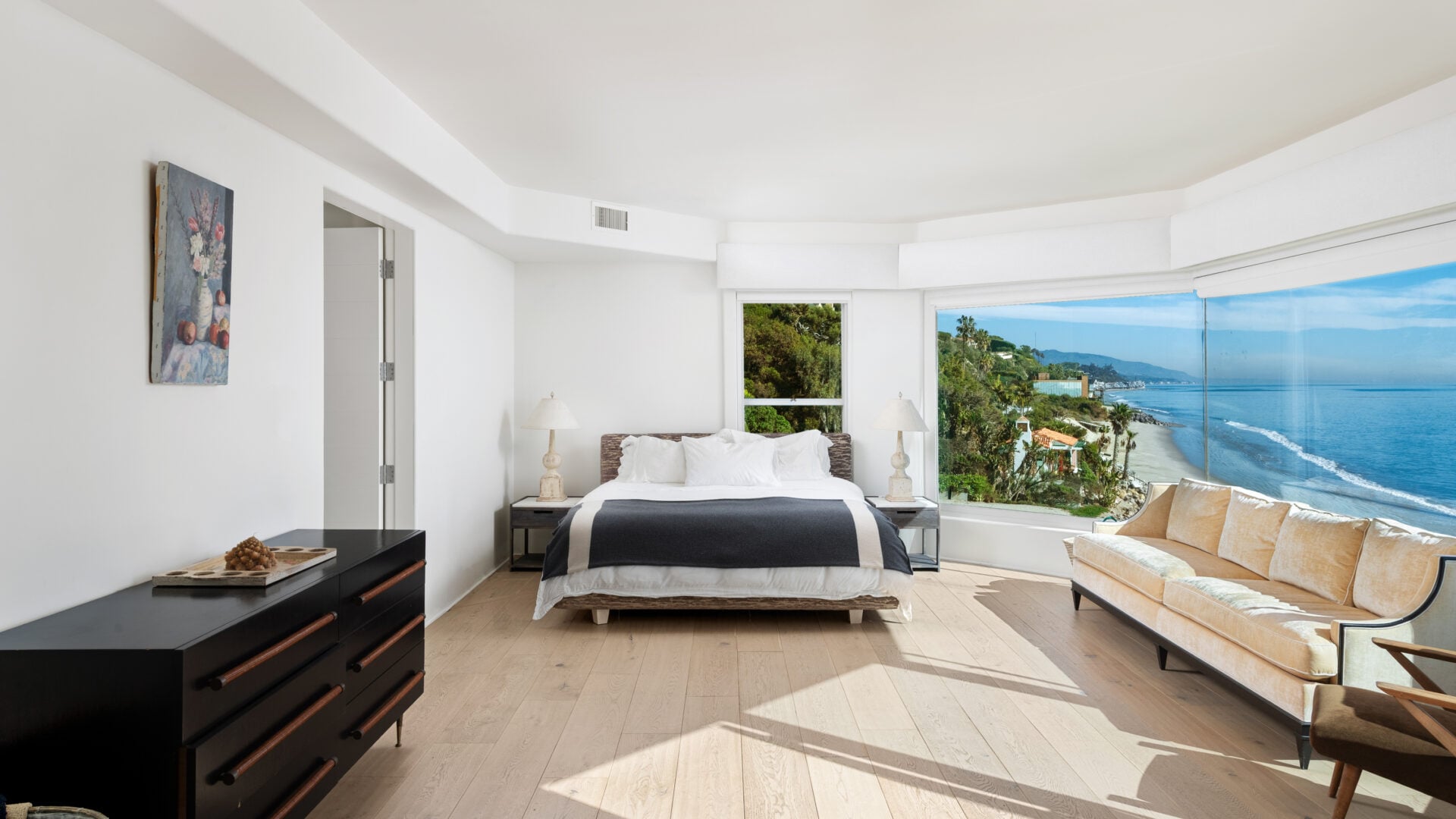 Primary suite with oceanfront view through large windows.