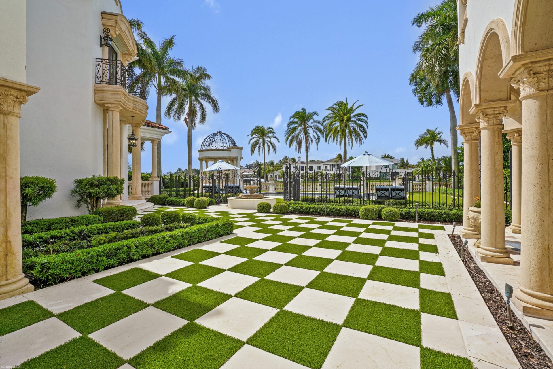An uncovered terrace in a checkered pattern of stone and grass. 
