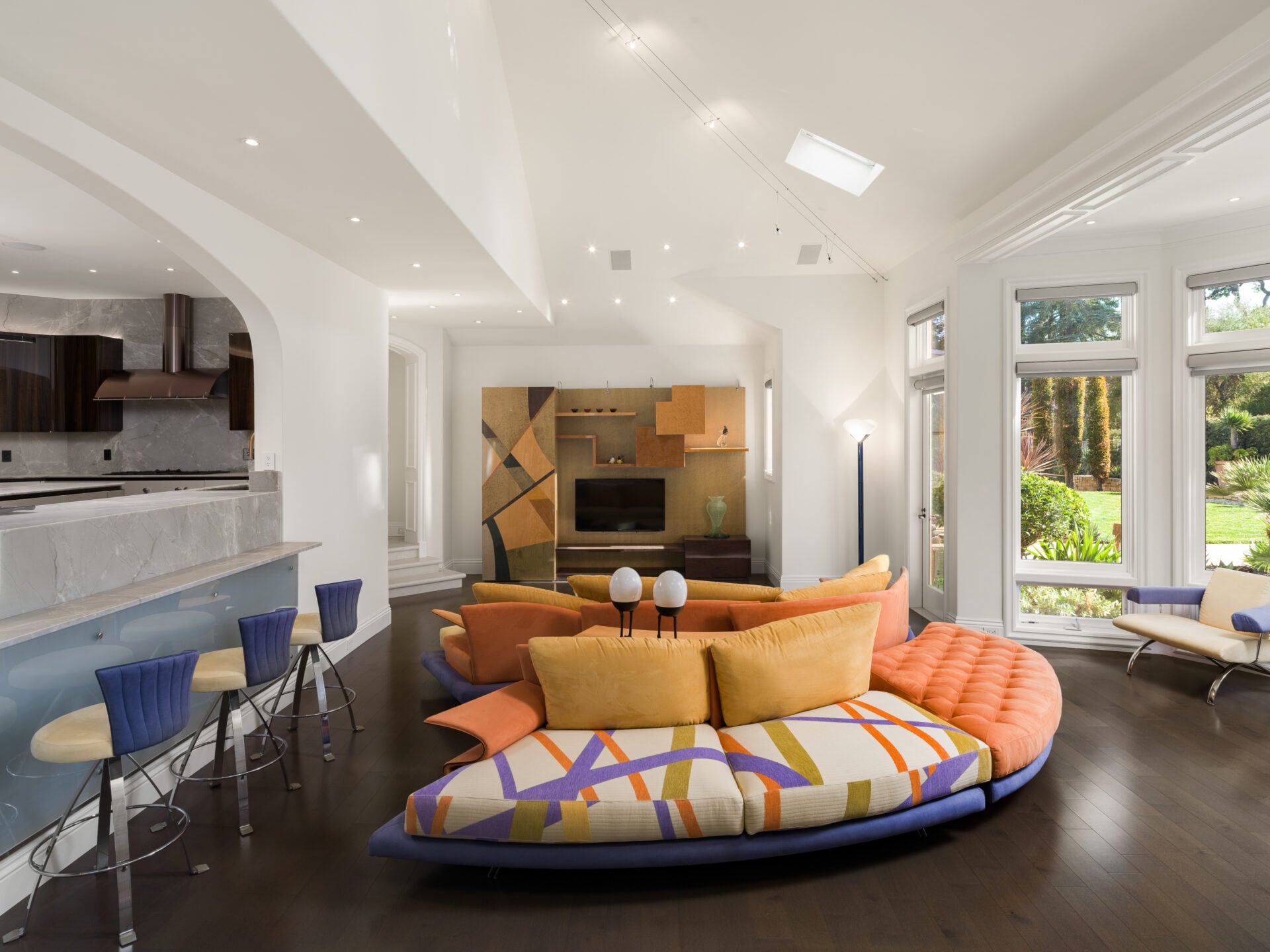 Family room with a breakfast bar along the kitchen side and windows on the other.