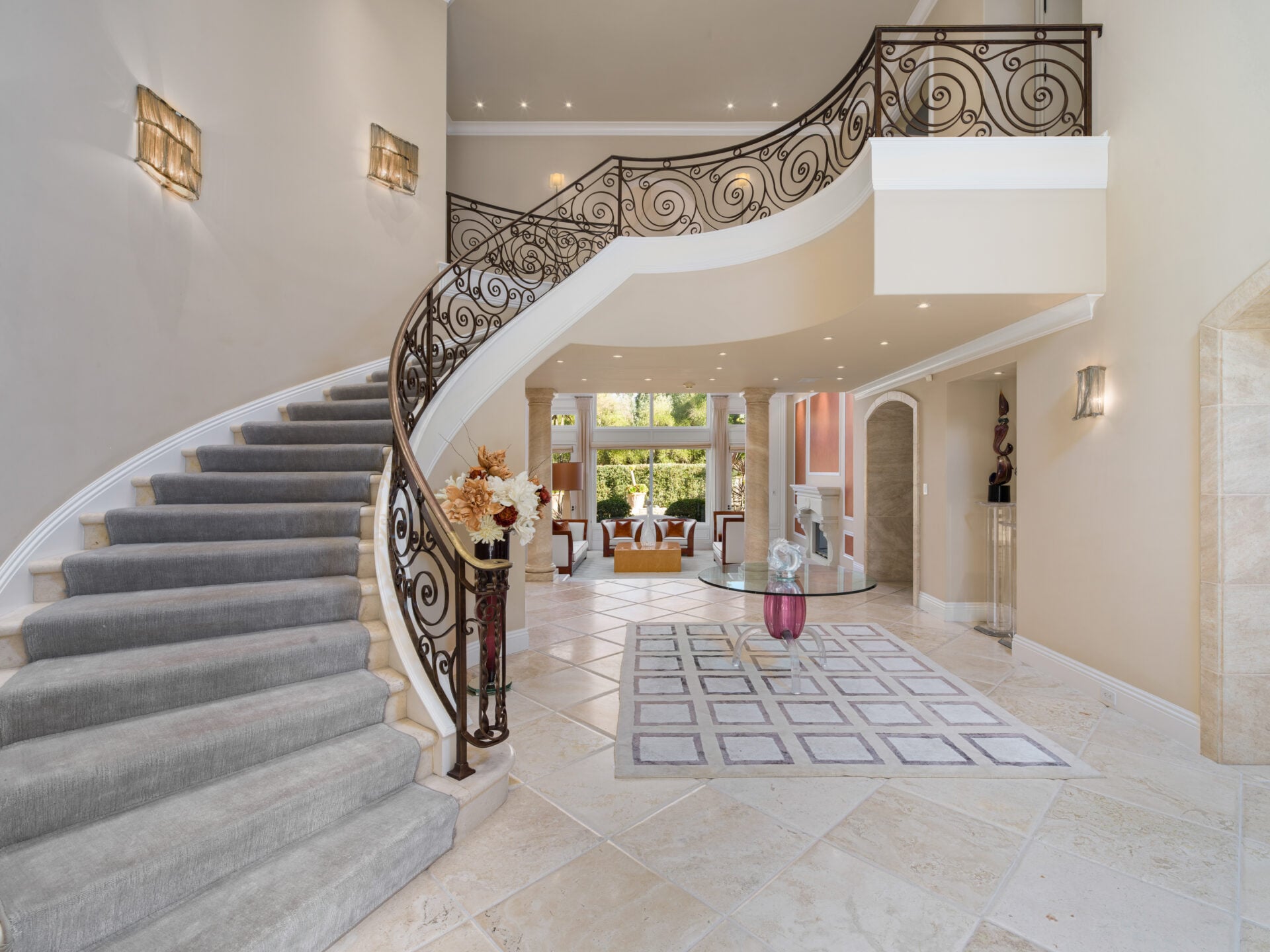 Foyer with Versace limestone flooring extending beneath soaring ceilings and Venetian plaster walls.
