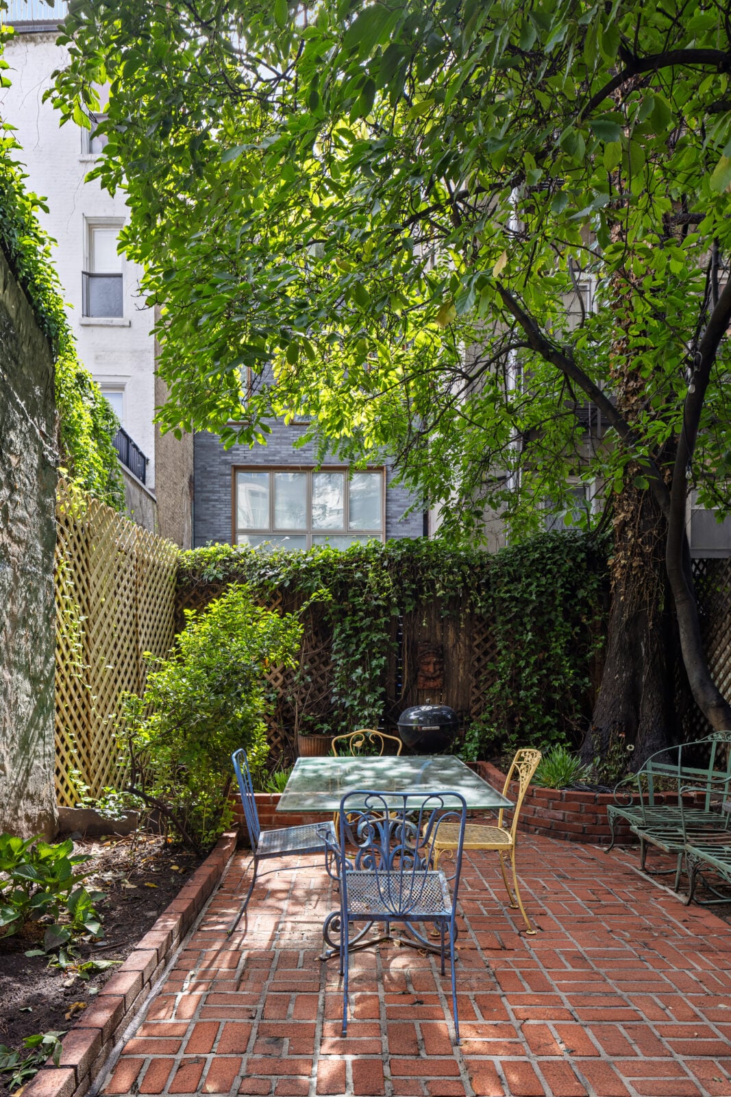 A back garden with outdoor seating and a grill.